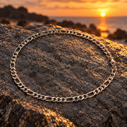 Colar masculino prateado sobre pedra ao pôr do sol